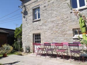 een groep tafels en stoelen voor een stenen gebouw bij Maison Bretagne in Matignon