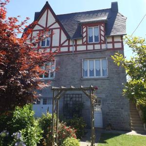 une maison avec une tonnelle devant elle dans l'établissement Maison Bretagne, à Matignon