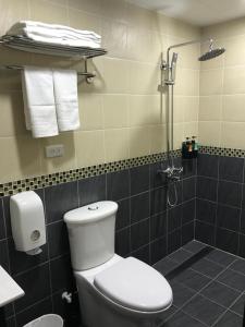 a bathroom with a toilet and a shower with towels at 177 Guest House in Nantou City