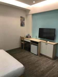a hotel room with a desk with a flat screen tv at 177 Guest House in Nantou City