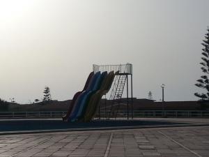 a slide in a park with a playground at El Zohour Chalet North Coast in El Alamein