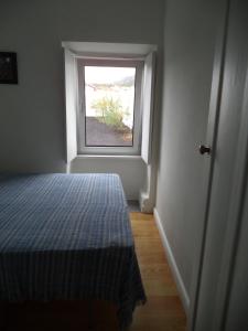 um quarto com uma cama e uma janela em Casa Comprida em Santo Amaro