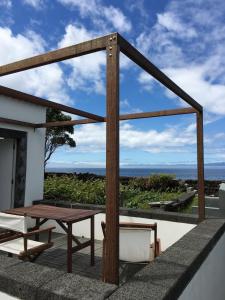 um pátio com uma mesa de madeira e uma mesa de piquenique em Casa Comprida em Santo Amaro