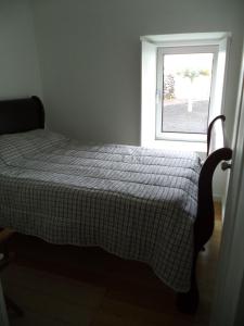 a bed in a room with a window at Casa Comprida in Santo Amaro
