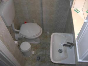 a small bathroom with a toilet and a sink at Gouna's Aparts in Xi
