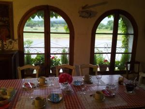 a table with glasses and flowers on it with windows at Riverside Home Cottage in Trèbes