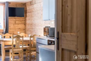 a kitchen and dining room with a table and chairs at Nazca C6 in Val Thorens