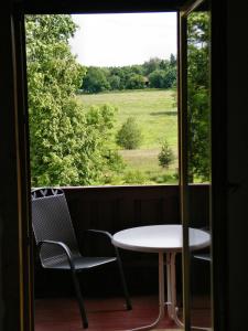 Apartments Carmen-Braunlage في برونلاغ: طاولة وكراسي على شرفة مع نافذة