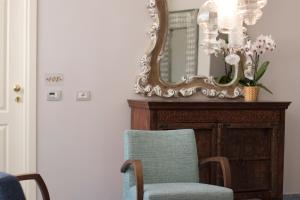 a mirror and a chair in front of a dresser at Hotel Soleluna in Piano di Sorrento