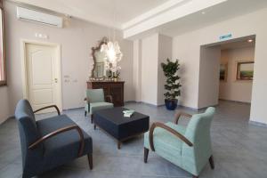 a living room with chairs and a table and a mirror at Hotel Soleluna in Piano di Sorrento