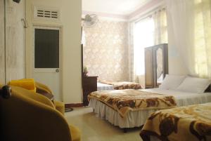 a hotel room with two beds and a window at Hoang Trang Hotel in Da Lat