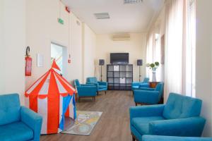 una sala d'attesa con sedie blu e una tenda di Hotel Sirena a Rimini