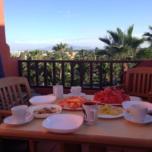 una mesa con platos de comida en el balcón en Oasis Royal, en Corralejo