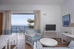 a living room with a view of the ocean at Anassa Mare Villas & Residences in Gaios