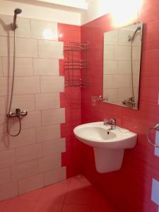 a red and white bathroom with a sink and a shower at Family Hotel Perla in Golden Sands