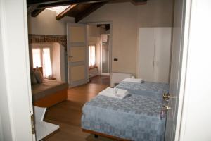 Habitación pequeña con 2 camas y sofá en Palazzo Sacco Hostello Fossano, en Fossano