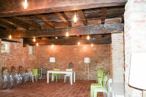 a room with tables and chairs and a brick wall at Palazzo Sacco Hostello Fossano in Fossano