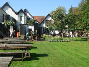 a group of picnic tables in a park with people sitting at The Olde Bell in Marlow