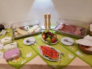 einen Tisch mit Tabletts mit Lebensmitteln und Obst in der Unterkunft Hotel Garni zum Goldenen Ring in Quedlinburg