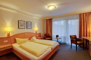 una camera d'albergo con letto, tavolo e sedie di Landhotel Püster ad Allagen