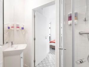 een witte badkamer met een wastafel en een douche bij Lisbon Serviced Apartments - Castelo S. Jorge in Lissabon