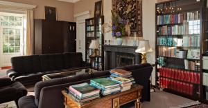 a living room with two couches and a table with books at Glanleam House in Valentia Island