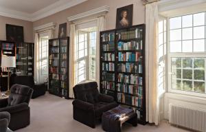 a library with two chairs and book shelves filled with books at Glanleam House in Valentia Island