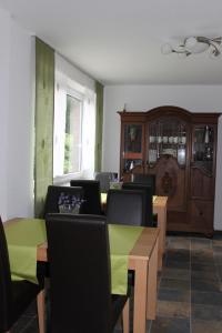 una sala da pranzo con tavolo e sedie verdi di Hotel Tau-Lünne a Haselünne