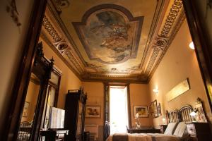 a bedroom with a ceiling with a painting on it at Palazzo Melluso LUXURY SUITE in Porto Empedocle