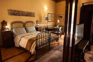 a bedroom with a bed and a table and a television at Palazzo Melluso LUXURY SUITE in Porto Empedocle