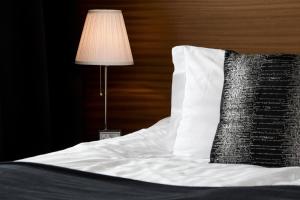 a bed with a white pillow and a lamp at Room With a View Apartments in Reykjavík