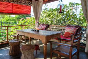 a wooden table and chairs on a balcony at Kamar Kamar Boutique Hotel in Seminyak