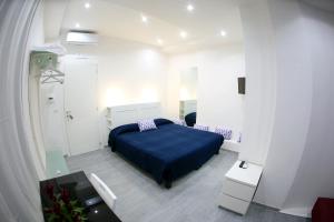 sypialnia z niebieskim łóżkiem w białym pokoju w obiekcie Cico B&B w mieście Napoli