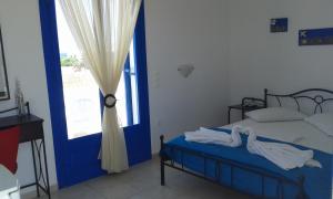 a bedroom with a bed with a blue door and a window at Vigles in Adamantas
