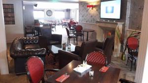 a restaurant with tables and chairs and a fireplace at Glendine Inn in Kilkenny