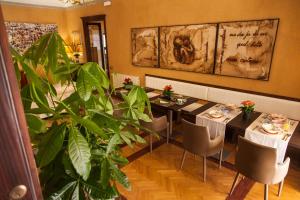 a dining room with two tables and a plant at Palazzo Melluso LUXURY SUITE in Porto Empedocle