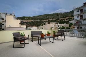 a patio with chairs and a table on a roof at Galanopoulos Hotel in Loutraki