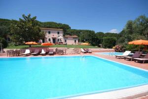 a large swimming pool with chairs and umbrellas at Residence della Luna in Porto Azzurro