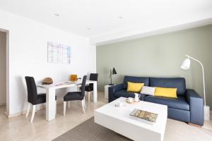sala de estar con sofá azul y mesa en Carretas Apartments, en Madrid