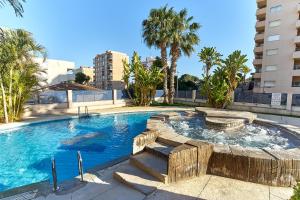 a swimming pool with palm trees and a building at Espanhouse La Zenia 109 in Orihuela Costa
