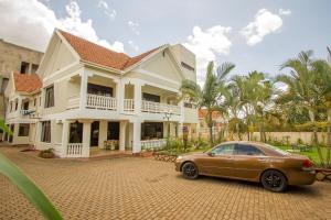 a car parked in front of a house at Tiptone Hotel in Kampala