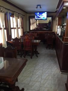 un restaurante con mesas y sillas y TV de pantalla plana en Patri Hotel en Chivilcoy