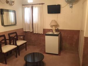 a living room with chairs and a table and a television at Patri Hotel in Chivilcoy