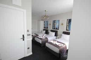 a hotel room with two beds and a door at Hotel Naumpasa Konagi in Istanbul