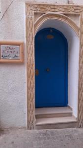 una puerta azul en el lateral de un edificio en Dar kenza Tunis, en Túnez