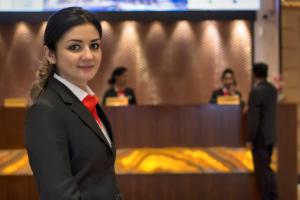 a woman wearing a suit and a red tie at Raintree Rolla Hotel in Dubai