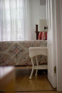 a room with a table and a couch with a lamp at Historic White Blossom House in Southold