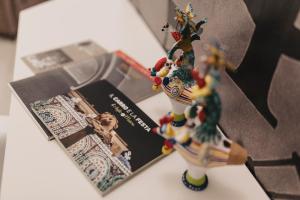 a book and a small figurine on a table at Il Giramondo Suite&Room in Matera +23 photos