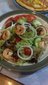 a plate of food with shrimp and vegetables on a table at Dahla House Ranong in Ranong +14 photos