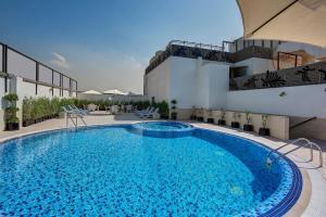 a large swimming pool in front of a building at Raintree Rolla Hotel in Dubai